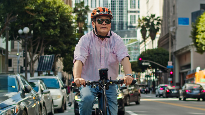 Man rides e-bike down bike lane on a sunny day