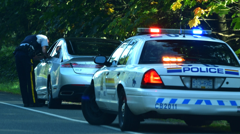 Car pulled over by police with an officer talking to the driver