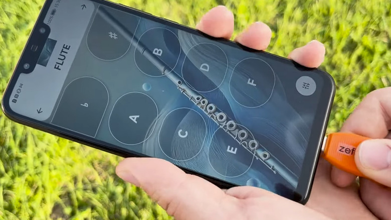 An Artinoise Zefiro being plugged into a smartphone showing the Zefiro app set to flute.