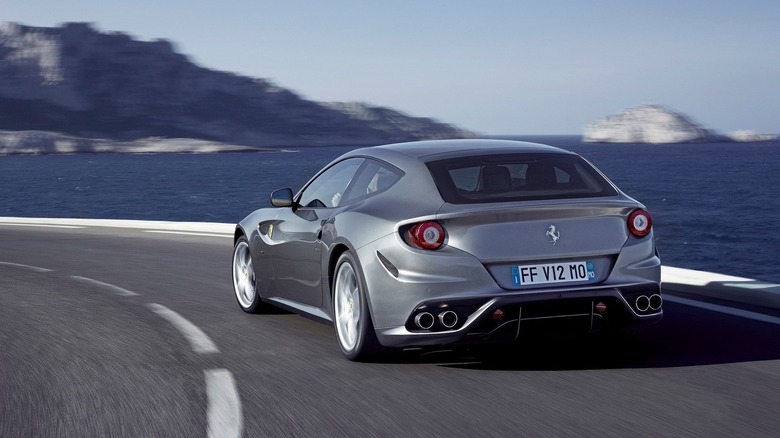Rear 3/4 view of Ferrari FF driving on winding seaside road