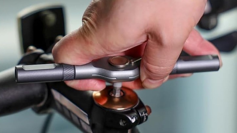 Ratchet screwdriver being used on a bicycle handlebar stem