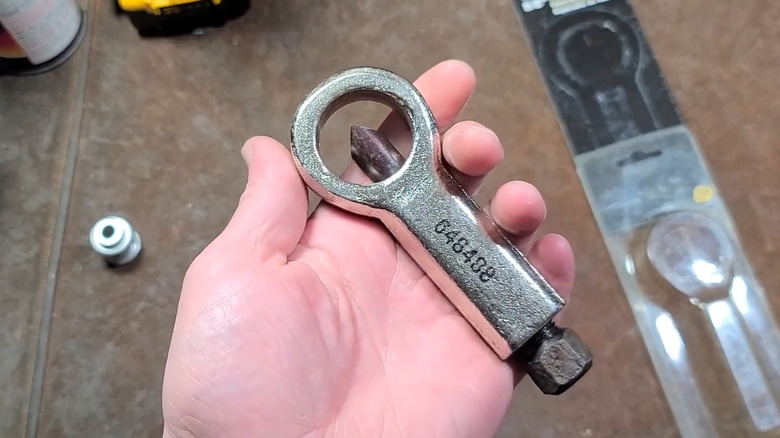 Man holding PowerBuilt nut splitter tool over table