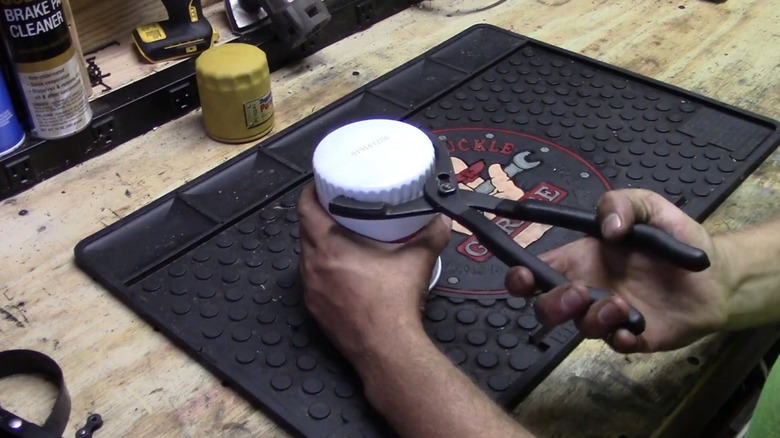 A person demonstrating how to use oil filter pliers