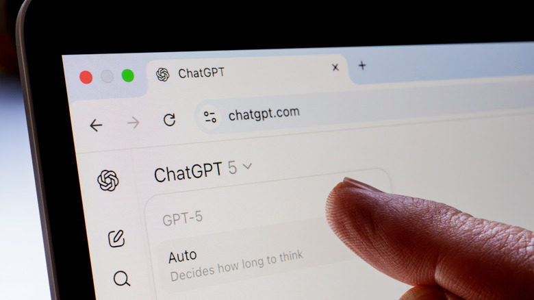 finger points at laptop screen with ChatGPT window
