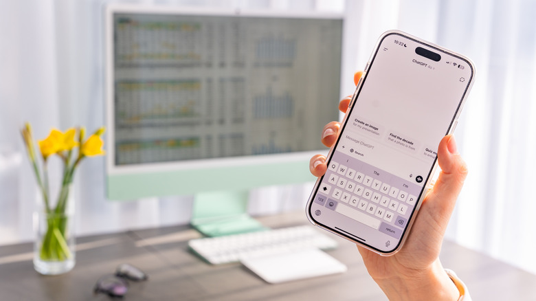 person holding iPhone with ChatGPT app open