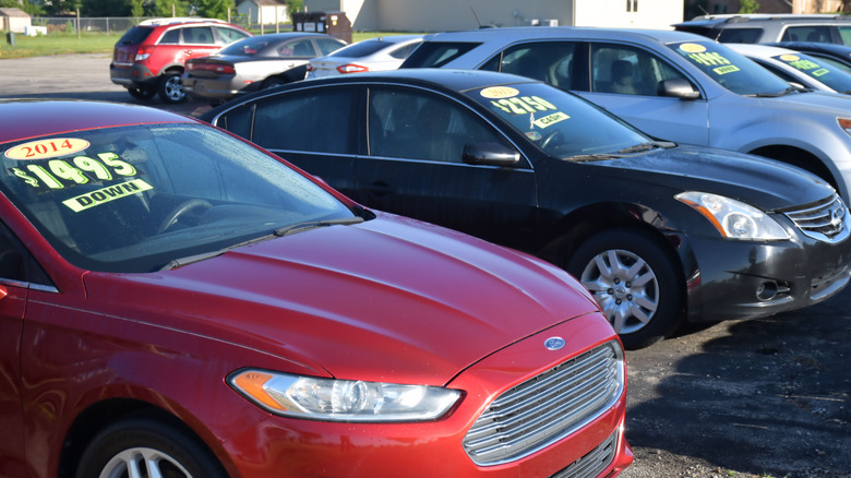 Picture showing a used cars sign against a cloudy background