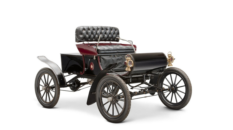 A restored 1903 Oldsmobile Curved Dash Runabout with a maroon trim