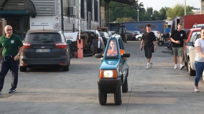 Andrea Marazzi customized thin Fiat Panda driving through a salvage yard.