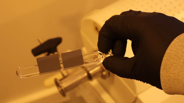 Dr. Semiconductor's gloved hand holding silicon chips during RAM array manufacture