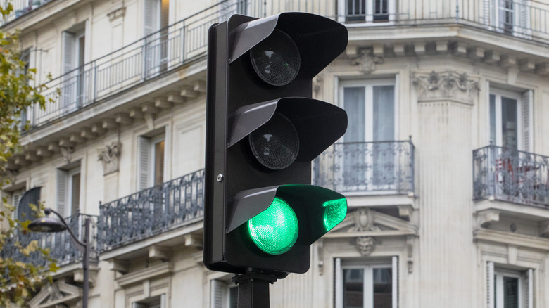 A traffic light on a pole illuminated green.