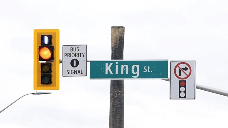 Traffic light with bus priority signal against a white sky