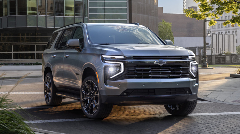 A gray Chevrolet Tahoe parked in a business district.