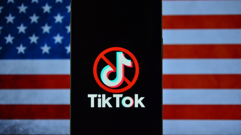TikTok logo on a phone against the backdrop of a US flag.