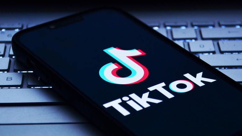 Phone with TikTok logo on computer keyboard