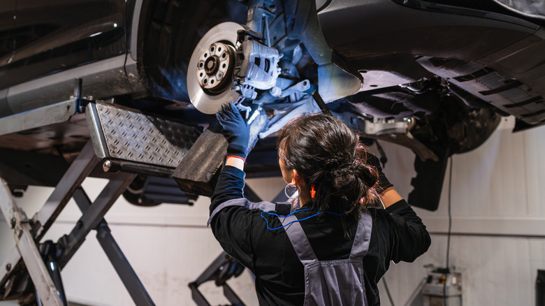 female mechanic working on car brake