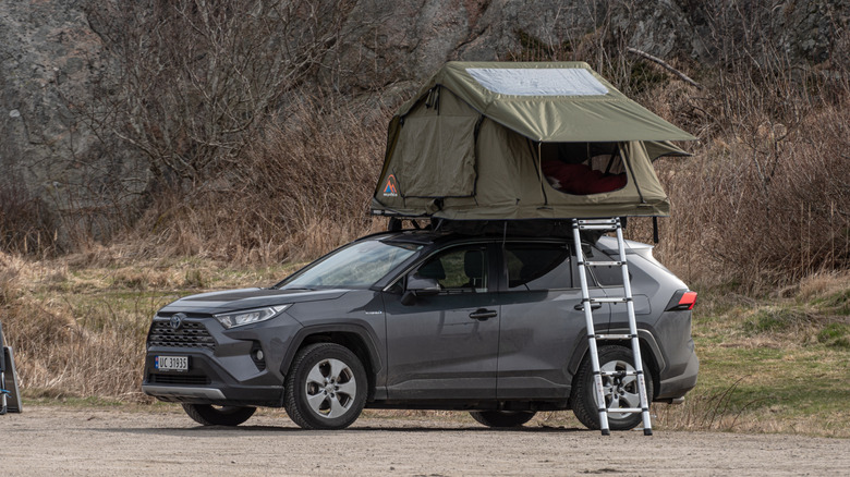 Side view of gray Toyota RAV4 with roof top tent.