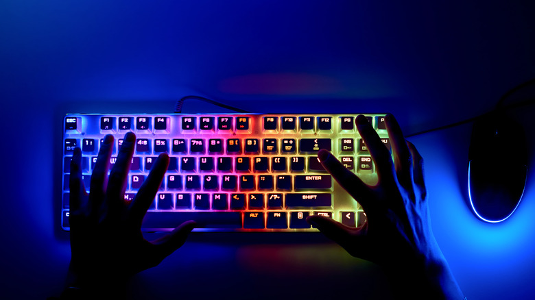 A person typing on an RGB mechanical keyboard