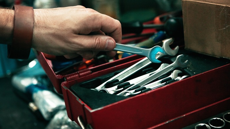 hand placing wrench inside tool box