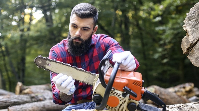 person inspecting chainsaw