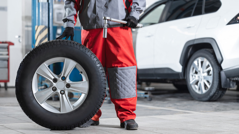 A mechanic replacing tires on a car.