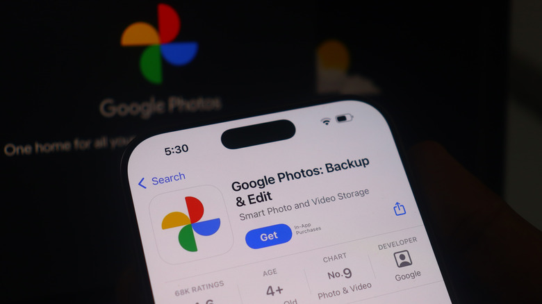 Phone showing Google Photos in Apple App Store with Google Photos icon in the background