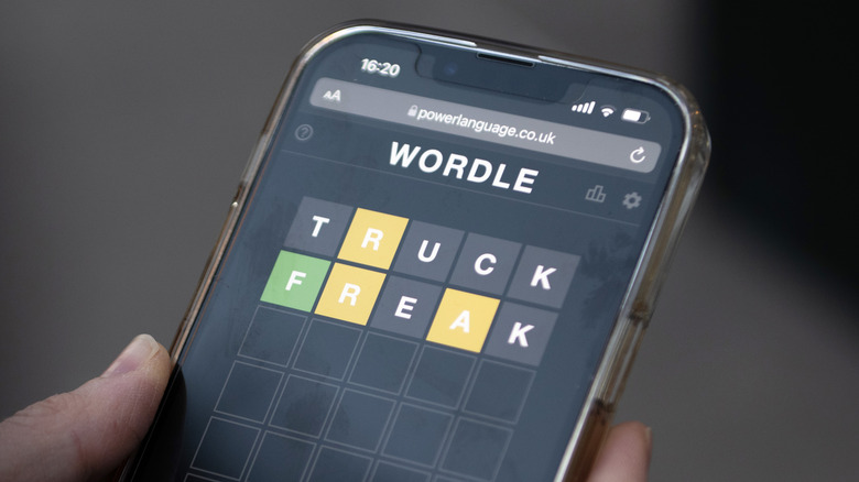 person playing Wordle smartphone