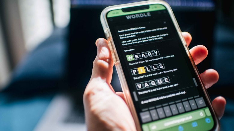 person playing Wordle smartphone