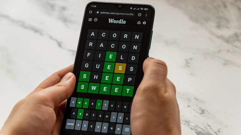 person playing Wordle smartphone