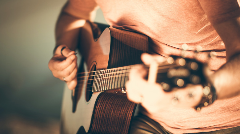 person strumming a guitar