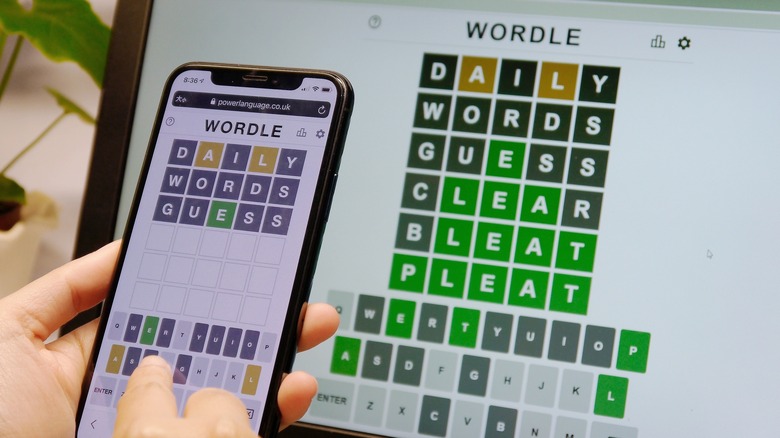 person playing Wordle smartphone