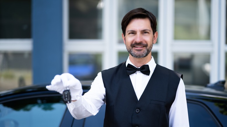 valet holding key outside car