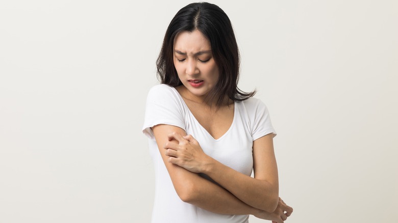 woman scratching her arm