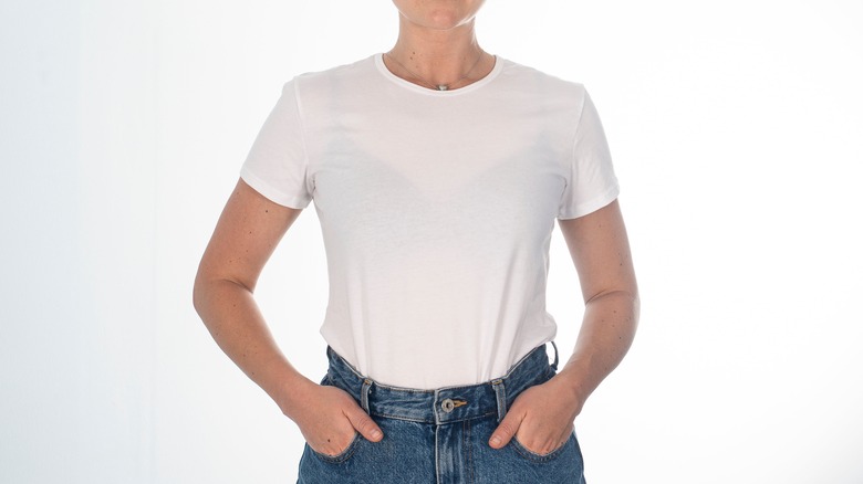 torso of woman wearing white tee and blue jeans