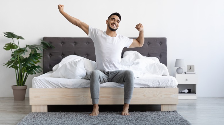 Man stretching on bed