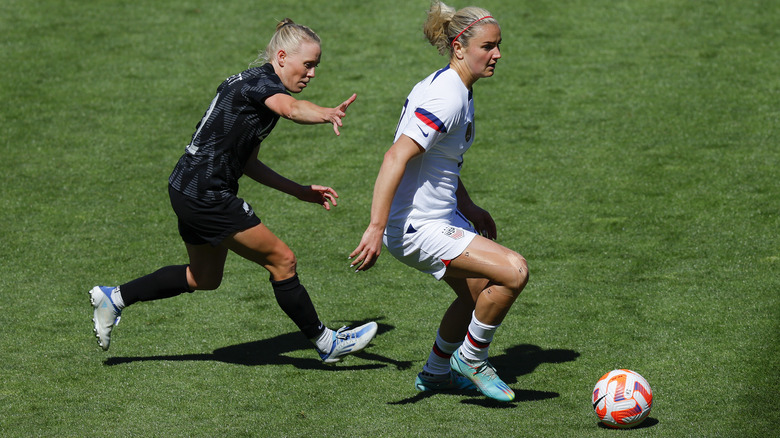 female football player evading another