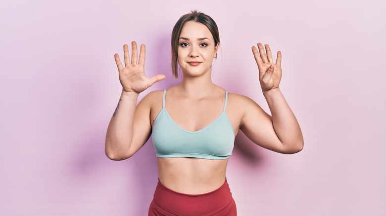 woman holding up nine fingers