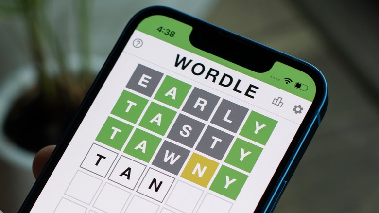 person playing Wordle smartphone