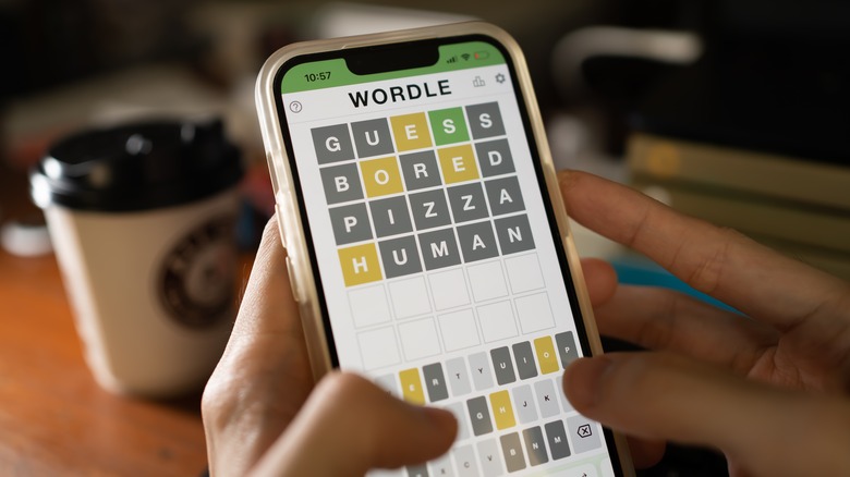 person playing Wordle smartphone