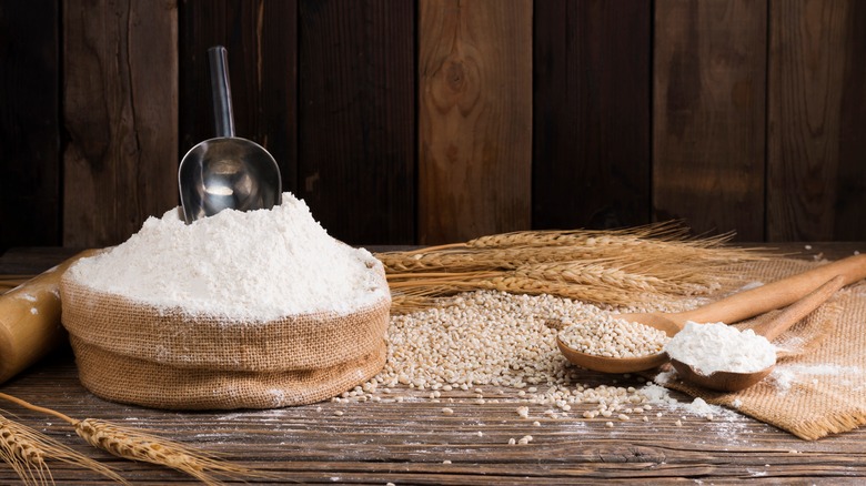 flour in a sack with ears of wheat laying beside