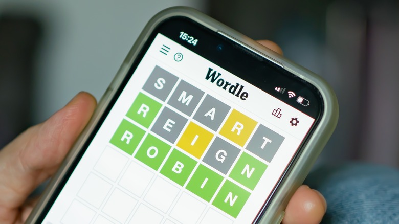person playing Wordle smartphone