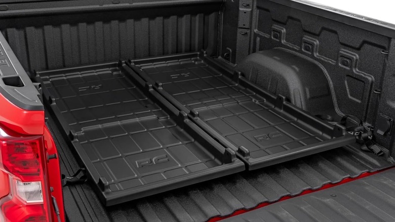 Two black plastic cargo trays on a black pickup bed