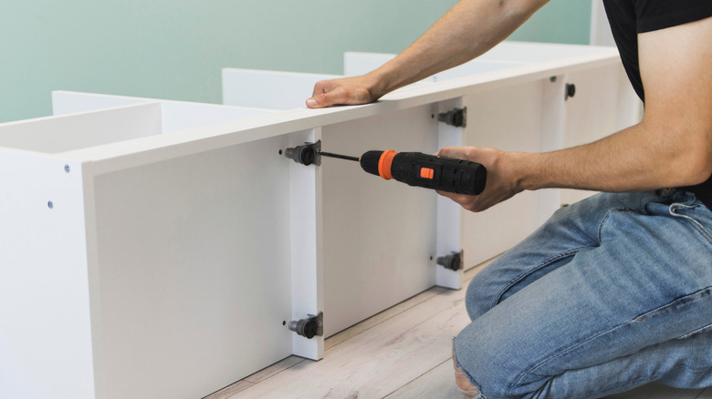 A young craftsman assembles furniture fittings.