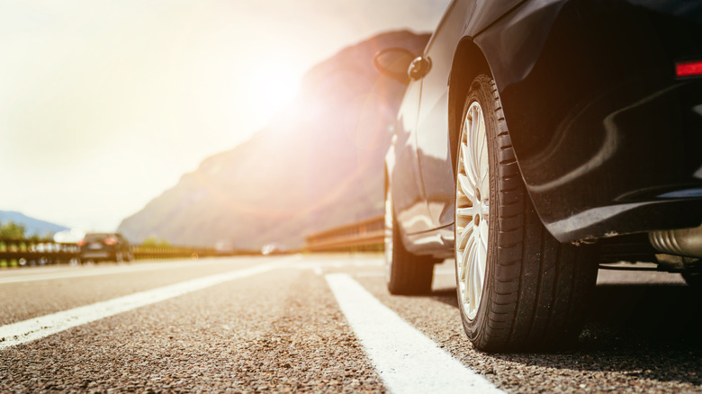 Closeup of tires on a car driving down a road