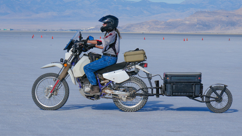 A man riding his adventure motorcycle and towing a trailer