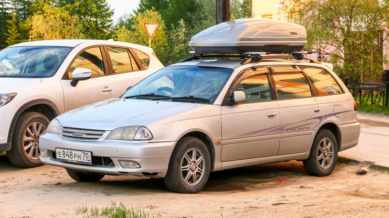A gray Toyota Caldina parked at a beach