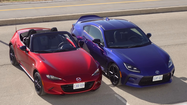 Red mazda miata parked next to blue toyota gr86