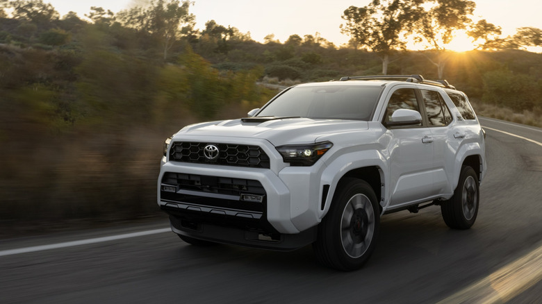 Front 3/4 view of white Toyota 4Runner on rural road.