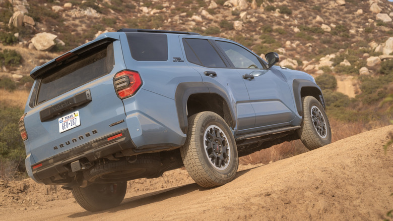 Rear 3/4 view of blue Toyota 4Runner on desert trail.