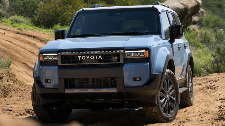 Heritage Blue 2027 Toyota Land Cruiser driving on a dirt road