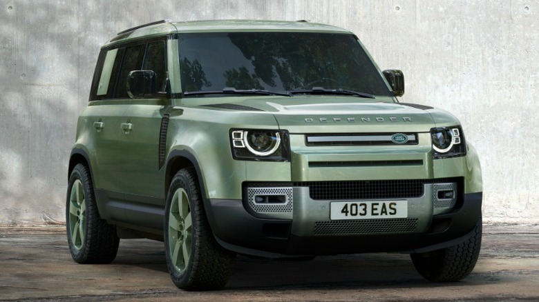 Green Land Rover Defender 110 75th Limited Edition parked in front of modern building